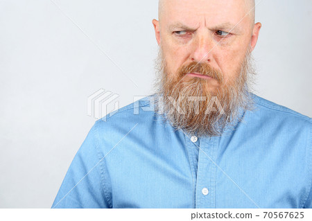 portrait of a man with a beard looking unhappy 70567625