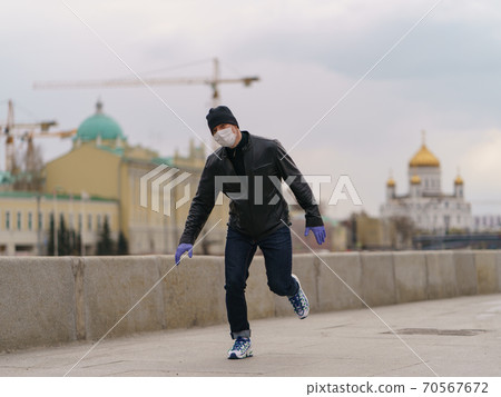 Man wearing protective mask outdoors. Coronavirus pandemic time. 70567672