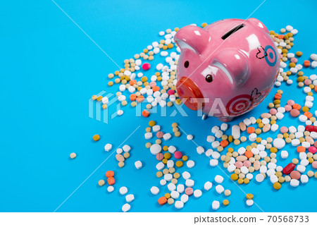 concept for medical expenses, Tablets and piggy bank on blue background 70568733