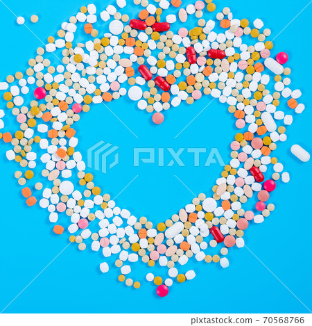 Many pills in the form of a heart Multicolored on a blue background 70568766