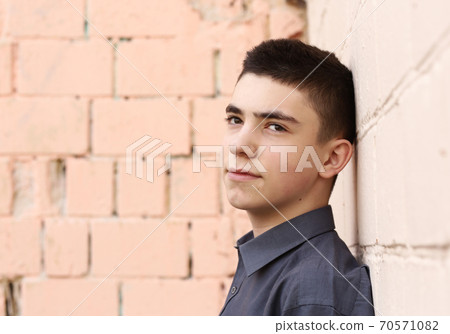 happy teenager boy wink closeup portrait on white wall background 70571082