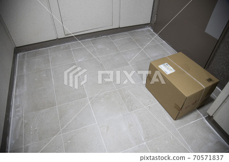 A delivery box placed in front of the apartment entrance A delivery box placed in front of the apartment entrance 70571837
