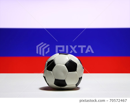 Small football on the white floor and Russian nation flag with white blue and red color background. Small football on the white floor and Russian nation flag with white blue and red color background. 70572467