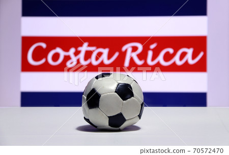 Small football on the white floor and Costa Rican nation flag. Small football on the white floor and Costa Rican nation flag. 70572470