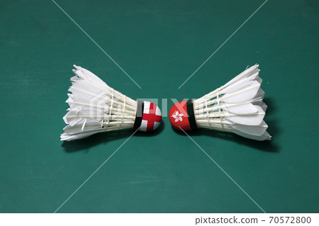 Two used shuttlecocks on green floor of Badminton court with both head each other. 70572800