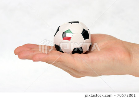 Mini football in hand and one black point of football is Kuwait flag on white background. Mini football in hand and one black point of football is Kuwait flag on white background. 70572801