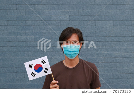 Masked man in brown shirt and South Korea flag in hand. Masked man in brown shirt and South Korea flag in hand. 70573130