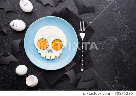 Fried eggs in the shape of a skull. Halloween breakfast. Fried eggs in the shape of a skull. Halloween breakfast. 70575280