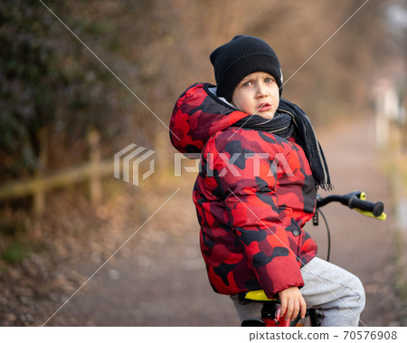 Sad kid on bicycle at park 70576908