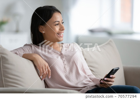Smiling biracial female use cellphone dream at home Smiling biracial female use cellphone dream at home 70577294