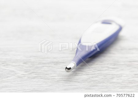 Electronic body thermometer on a white wooden background. Medical instrument Electronic body thermometer on a white wooden background. Medical instrument 70577622