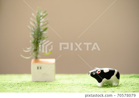 (2021, Ox) A figurine cow standing in the meadow that can be used for New Year's cards 70578079