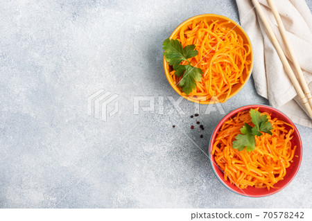 Raw grated spicy carrot salad in bowl. Korean carrot with spices and sauce. Copy space 70578242