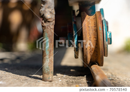 A rusty wheel from sliding gate on a rail, close up view 70578540