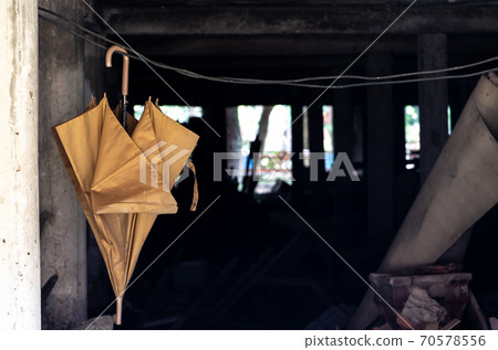 Old umbrella hanging on a rope in the basement of a building, Thailand. Old umbrella hanging on a rope in the basement of a building, Thailand. 70578556