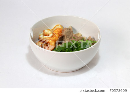 Boiled instant noodles with pork rip, fried egg, fish meat and green vegetable in the white bowl. 70578609