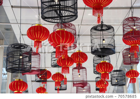 Red fabric lamps and bird cage lamps hanging on the ceiling. Red fabric lamps and bird cage lamps hanging on the ceiling. 70578685