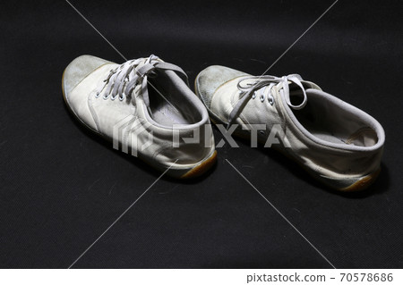 Used sneakers shoes in white color but it grimy and Gloomy color, put pair on black floor. Used sneakers shoes in white color but it grimy and Gloomy color, put pair on black floor. 70578686