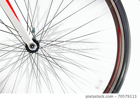 The front wheel of the bicycle rotates quickly on a white background. The front wheel of the bicycle rotates quickly on a white background. 70579113