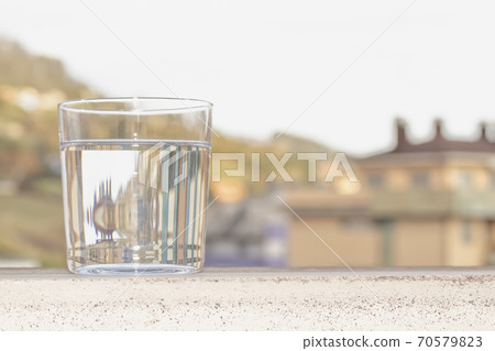A glass of clear water on the background of a city street A glass of clear water on the background of a city street 70579823