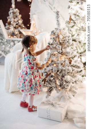Smiling lovely baby girl in cute dress with lots Smiling lovely baby girl in cute dress with lots 70580315