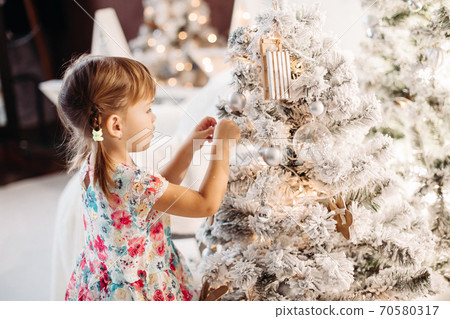 Smiling lovely baby girl in cute dress with lots Smiling lovely baby girl in cute dress with lots 70580317