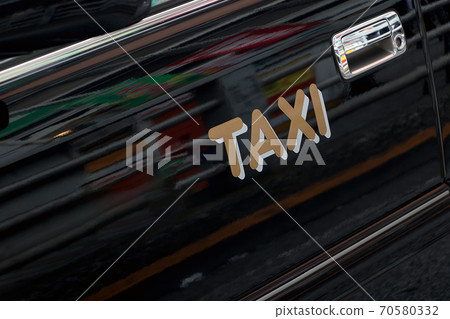 Taxi sign on the door of a taxi car in the streets. Taxi sign on the door of a taxi car in the streets. 70580332