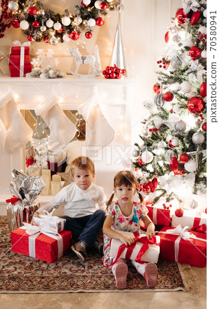 Brother in deer Christmas hat kissing his younger 70580941