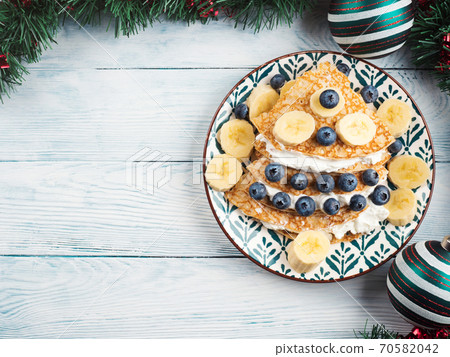 Christmas tree shaped sweet crepe with blueberries Christmas tree shaped sweet crepe with blueberries 70582042