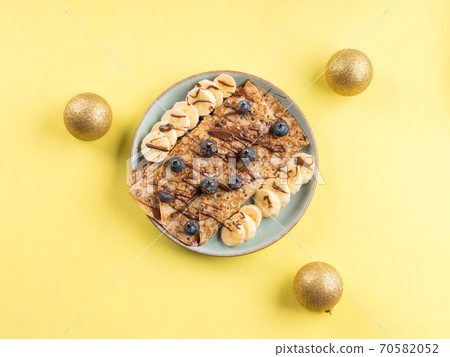 Crepes with chocolate nut spread, banana, berries 70582052