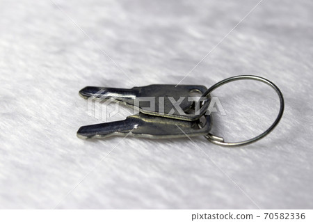 Mini metal two keys put on the white fabric floor. 70582336