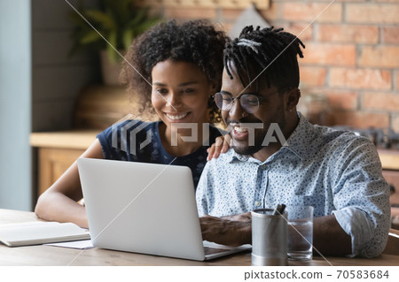 Happy African American couple work on laptop at home 70583684
