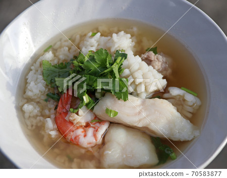 rice congee mixed with Shrimp, fish, squid and pork, Garnish with coriander. rice congee mixed with Shrimp, fish, squid and pork, Garnish with coriander. 70583877