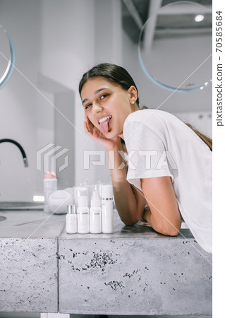 painting of a woman with cosmetic bottles in the bathroom 70585684