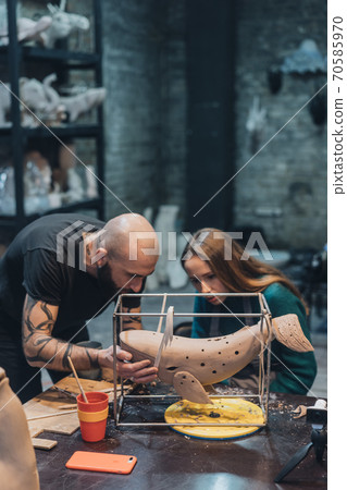 People carefully work on clay whale in workshop People carefully work on clay whale in workshop 70585970