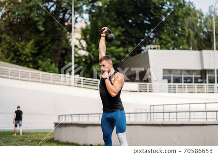 Sportive guy training with kettlebell. Strength and motivation. Sportive guy training with kettlebell. Strength and motivation. 70586653
