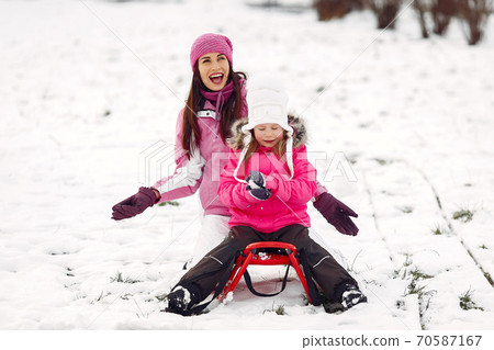 Mother and child in winter clothes play in winter park 70587167