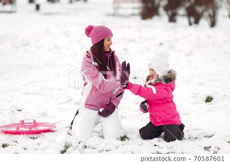 Mother and child in winter clothes play in winter park 70587601