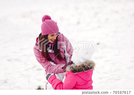 Mother and child in winter clothes play in winter park Mother and child in winter clothes play in winter park 70587617