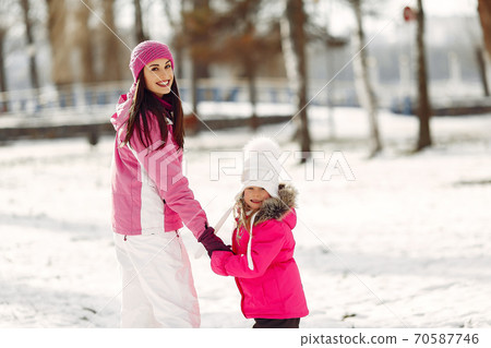 Mother and child in winter clothes play in winter park 70587746