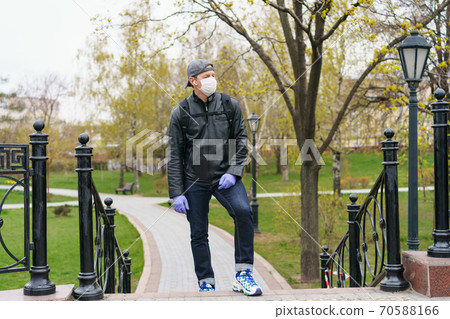 Man wearing protective mask outdoors. Coronavirus pandemic time. Man wearing protective mask outdoors. Coronavirus pandemic time. 70588166