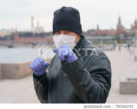 Man wearing protective mask outdoors in Moscow. Coronavirus pandemic time. Man wearing protective mask outdoors in Moscow. Coronavirus pandemic time. 70588245