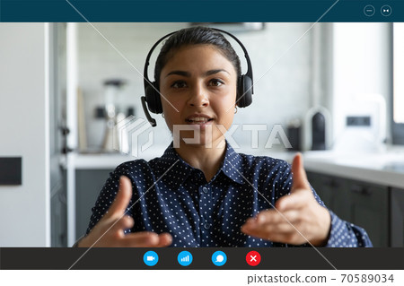 Head shot portrait screen view Indian businesswoman wearing headset speaking 70589034