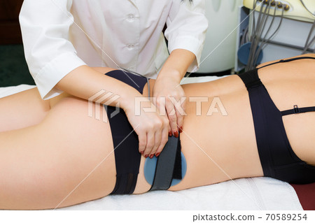 Myostimulation of the mouse on the buttocks. Myostimulation of the mouse on the buttocks. 70589254