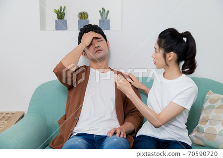 Woman takes the temperature of an uncomfortable man Woman takes the temperature of an uncomfortable man 70590720