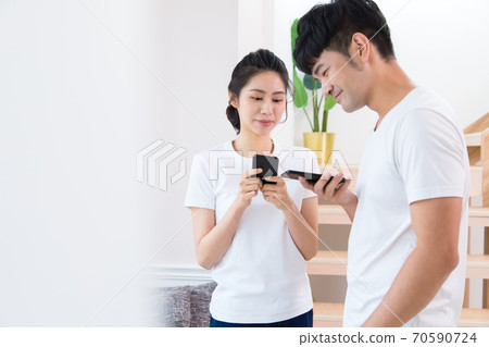 年輕的男人和女人在室內用智慧型手機 70590724