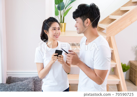 年輕的男人和女人在室內用智慧型手機 70590725