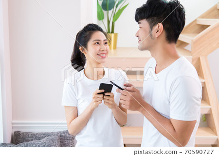 年輕的男人和女人在室內用智慧型手機 70590727