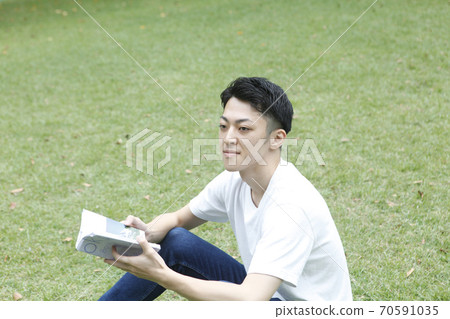 Young man reading sideways 70591035
