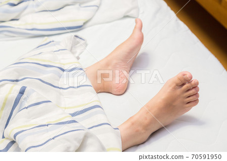 Women's feet coming out of the futon 70591950